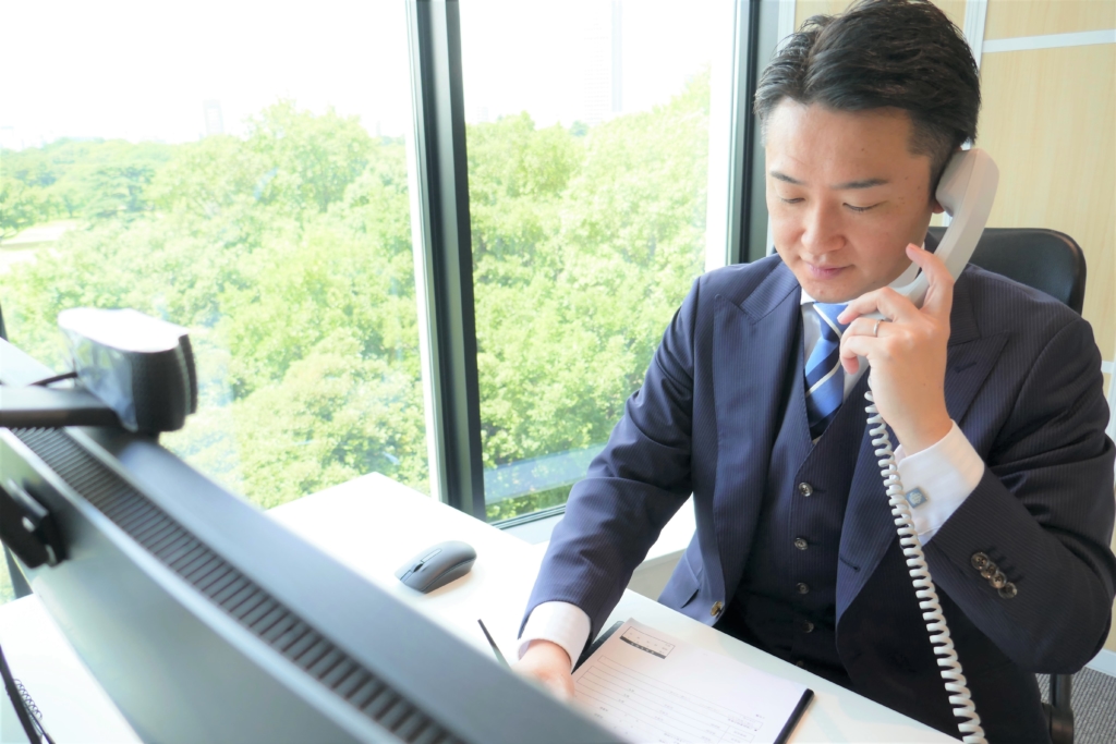 新宿の事務所で相談のお電話を受ける代表相談員 林 達治